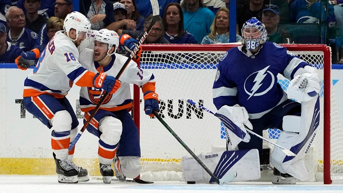 Hokejista New Yorku Islanders  Mathew Barzal (uprostred) sa teší po strelení gólu.