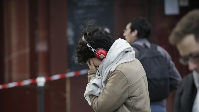 Plačúca žena pred barom Carillon, kde sa odohral jeden z útokov.