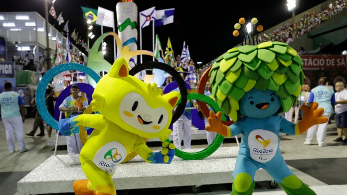 Maskoti OH - žltá mačka (vľavo), symbol paralympiády - modrá figúrka so zelenými vlasmi v tvare listov.