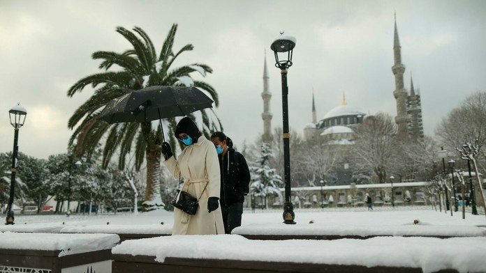 Ľudia kráčajú ulicami Istanbulu počas sneženia v pondelok 24. januára 2022.