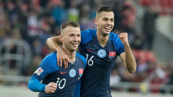 Slovenskí reprezentanti Albert Rusnák (vľavo) a Dávid Hancko oslavujú gól v dueli Ligy národov proti Ukrajine.
