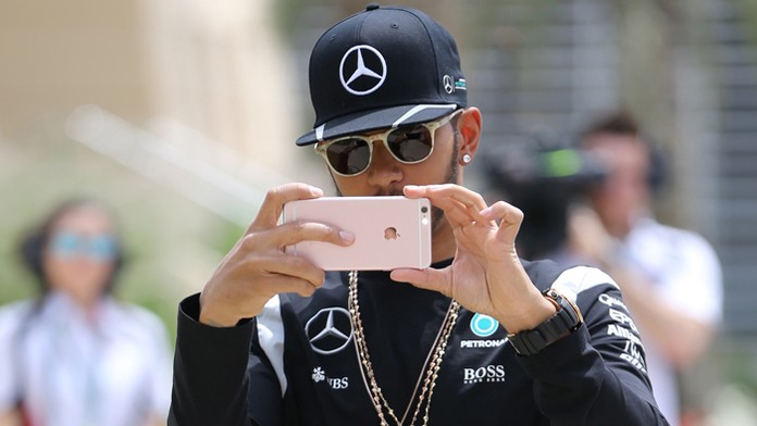 Britský jazdec tímu Mercedes Petronas Lewis Hamilton fotografuje skupinu fotografov v padoku.