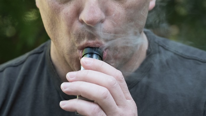 Muž fajčí elektronickú cigaretu.
