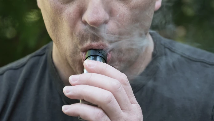 Muž fajčí elektronickú cigaretu.