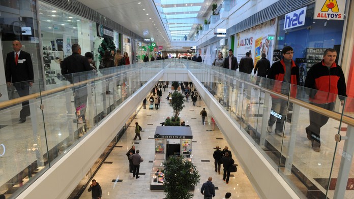 Snímka z obchodného centra, ľudia nakupujú, v rukách majú nákupné tašky.