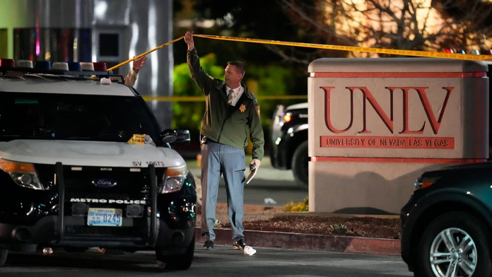 Policajt prechádza pod páskou miesta činu po streľbe na univerzite v Las Vegas.