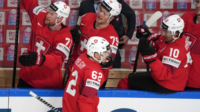 vajčiarsky hráč Denis Malgin (uprostred) oslavuje so spoluhráčmi na striedačke po tom, ako skóroval.