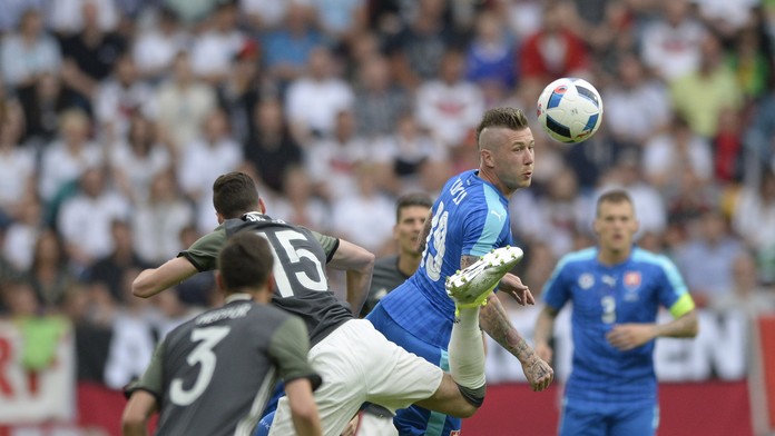 Juraj Kucka a Nemec Julian Draxler v hlavičkovom súboji v prípravnom zápase.