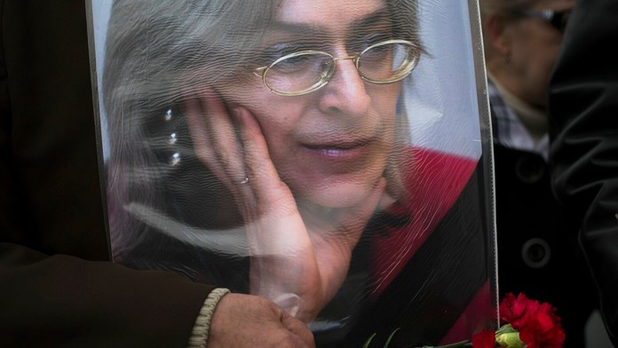 Staršia žena drží portrét zosnulej novinárky Anny Politkovskej.