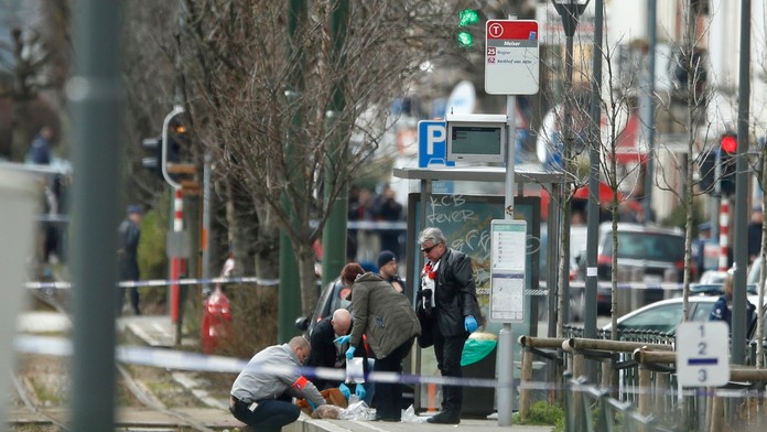 Policajní vyšetrovatelia zaisťujú stopy na električkovej zastávke počas policajnej akcie v belgickej štvrti Schaerbeek