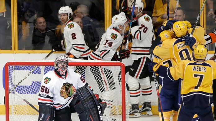 Brankár Chicaga Corey Crawford, tretí zľava Richard Pánik (14).
