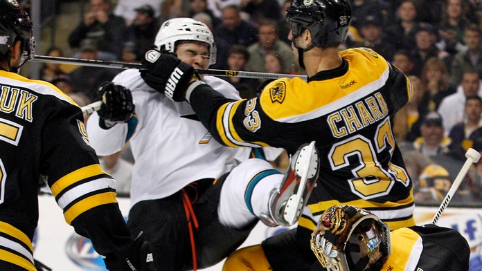 Kapitán Bostonu Bruins Zdeno Chára (druhý vpravo) a hráč San Jose Sharks Čech Tomáš Hertl v súboji pred brankárom Bostonu Tuukko