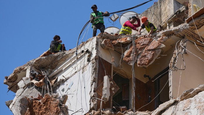 Pracovníci odpratávajú trosky zo zničenej obytnej budovy, kde pátrajú po nezvestných osobách - žene a dievčati na mieste izraelských leteckých útokov na obytnú budovu.