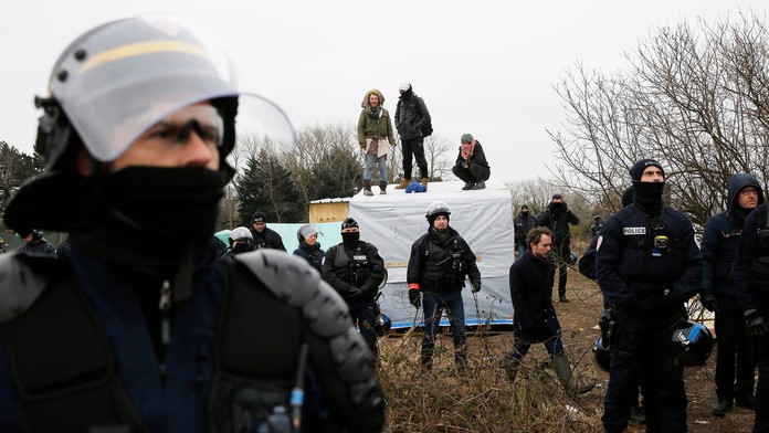 Migranti v tábore pri Calais protestujú na strechách búd.