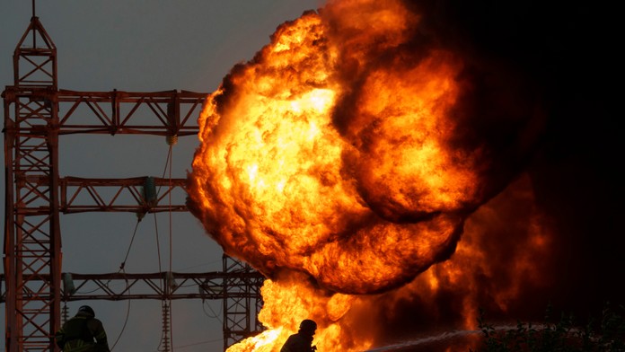 Príslušník záchranných zložiek zasahuje počas požiaru horiacej elektrickej rozvodne na Ukrajine.