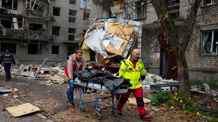 Záchranári odnášajú telo obete, ktoré našli v troskách zničenej bytovky po útoku v juhoukrajinskom meste Mykolajiv.