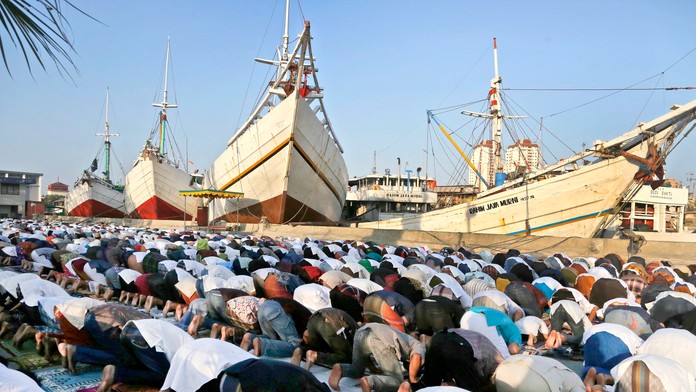 Moslimovia sa modlia pred starými drevenými škunermi v Jakarte