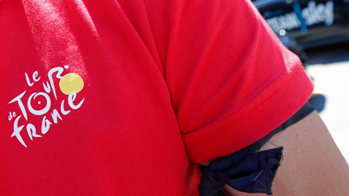 Organizátor TdF má na ruke uviazanú čiernu stužku za obete teroristického útoku z Nice.