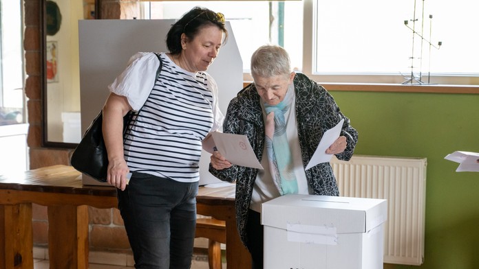 Na snímke volička s doprovodom vhadzuje obálku s hlasovacím lístkom do volebnej schránky v Prešove.
