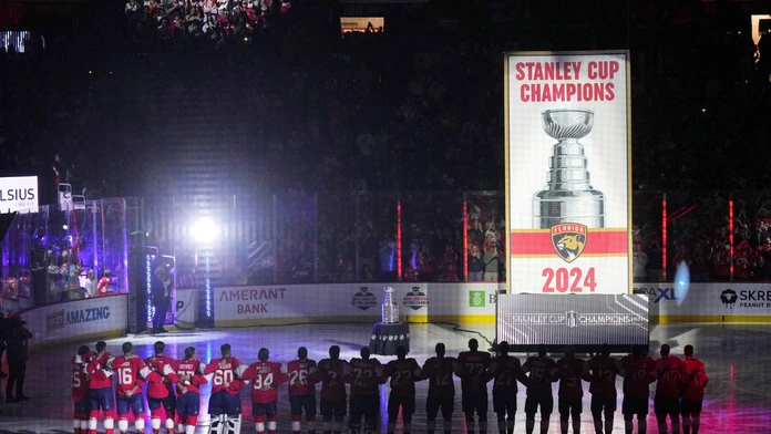 Obhajcovia Stanleyho pohára hokejisti Floridy Panthers stoja pri vztýčenej klubovej vlajke.