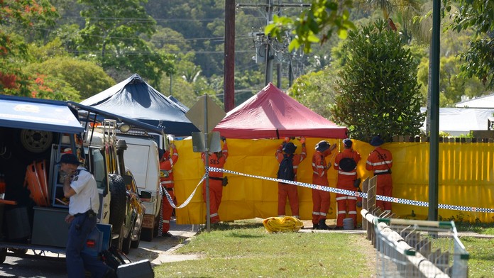 Záchranári dávajú pásku pred plot domu v austrálskom meste Cairns v štáte Queensland, kde polícia objavila osem mŕtvych detí a z