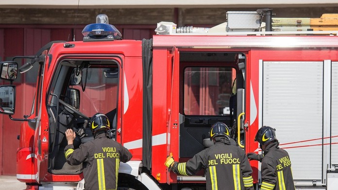 Talianski hasiči pred hasičským vozidlom.