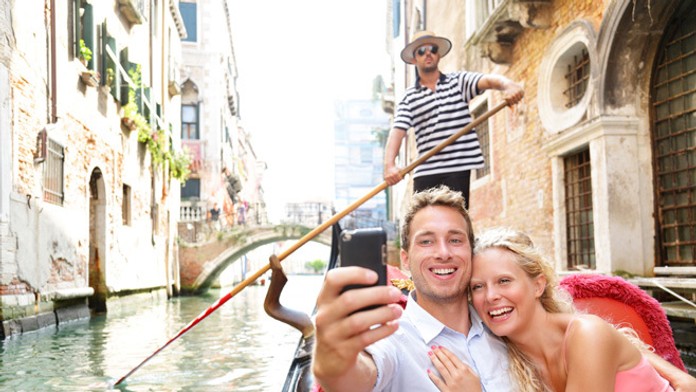 Mladý pár si robí selfie počas dovolenky v Benátkach.