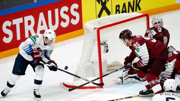 Trevor Moore si sklepáva puk pre lotyšskou bránkou.