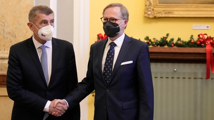 Odchádzajúci český premiér Andrej Babiš (vľavo) a nový český premiér Petr Fiala sa vítajú na úrade vlády v Prahe.