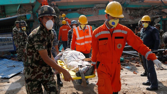 Na snímke záchranári vynášajú telo zo zrútného kostola po zemetrasení v nepálskom Káthmandu.