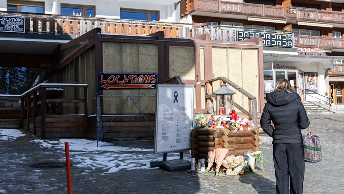 Žena stojí pred barom v luxusnom švajčiarskom lyžiarskom stredisku Crans Montana, kde pri novoročnom požiari zahynulo 40 ľudí.