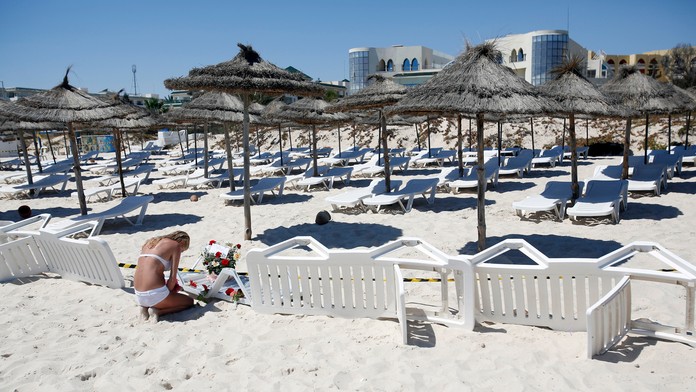 Mladá žena kladie kvety na pláž hotela Imperial Marhaba. 27. jún