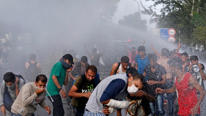 Migranti na srbskej strane hraníc pri juhomaďarskej obci Röszke stratili trpezlivosť, prerazili plot a začali utekať na maďarskú