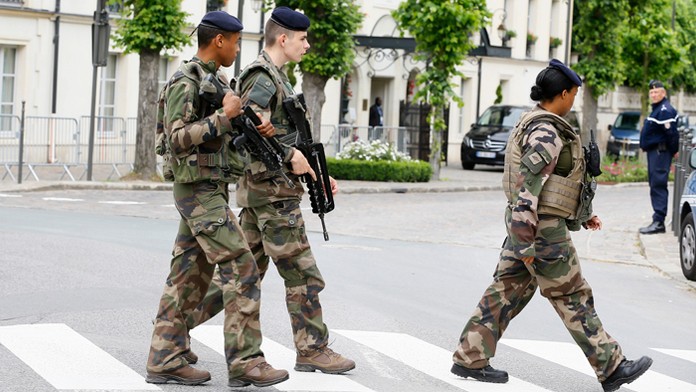 Francúzski vojaci hliadkujú pred hotelom, kde sú ubytovaní anglickí reprezentanti.