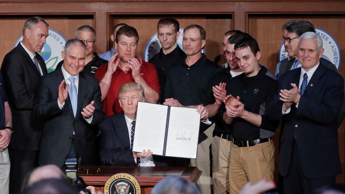 Americký prezident Donald Trump drží podpísaný dekrét.