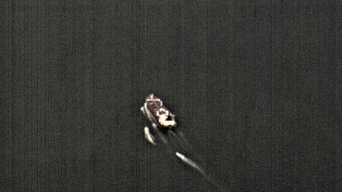 Na videosnímke tri plavidlá  iránskych revolučných gárd prenasledujú obchodné plavidlo v Hormuzskom prielive.