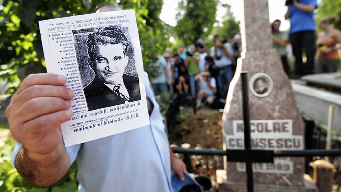 Na archívnej snímke muž drží leták s podobizňou  rumunského komunistického diktátora Nicolae Ceaušesca. 
