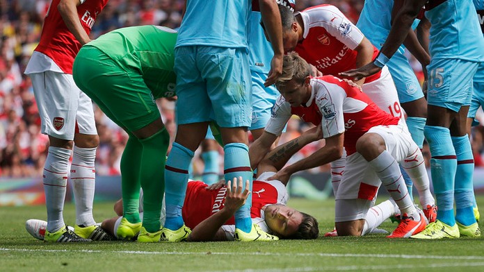 Futbalisti Arsenalu sa skláňajú nad svojím spoluhráčom Francúzom Olivierom Giroudom.