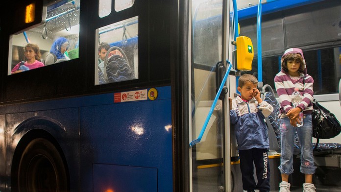 Deti sa pozerajú z autobusu, ktorý ich previezol z Budapešti až na rakúsku hranicu k obci Nickelsdorf.