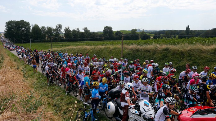 Cyklisti čakajú po tom, čo 16. etapu Tour de France prerušil protest farmárov.