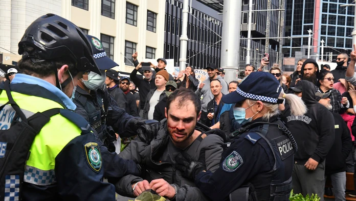 Policajti zadržujú protestujúceho počas demonštrácie proti lockdownu 24. júla 2021 v Sydney.