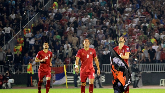 Stefan Mitrovič (Srbsko) strháva albánsku vlajku, ktorá na minihelikoptére lietala na konci 1. polčasu zápasu Srbsko - Albánsko.