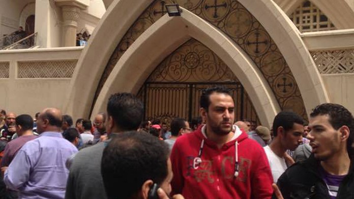 Veriaci stoja pred koptským kostolom po výbuchu bomby na Kvetnú nedeľu.