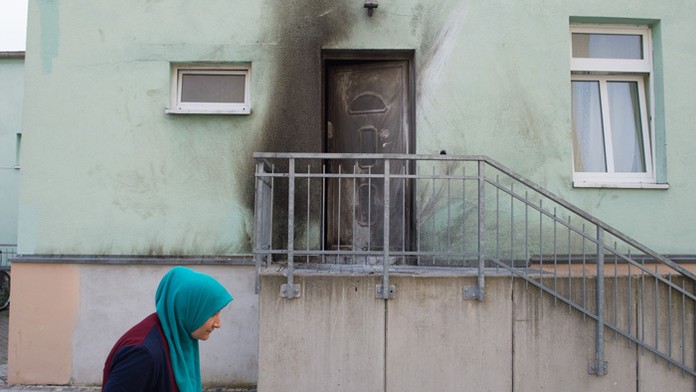 Žena kráča pred vchodom mešity Fatih Camii v Drážďanoch.