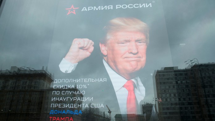 Budova veľvyslanectva USA sa odráža na okne obchodu s plagátom Donalda Trumpa v Moskve.