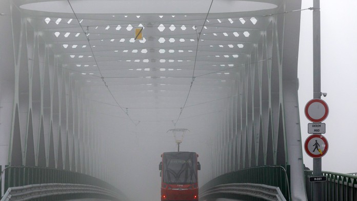 Na snímke električka jazdí po Starom moste počas hmlistého počasia v Bratislave.