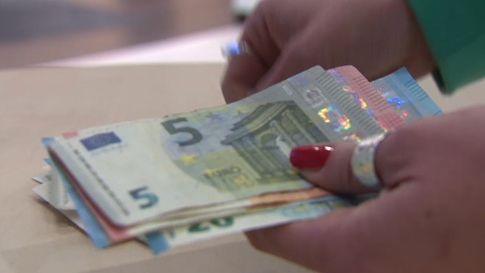 Na snímke žena počíta peniaze.