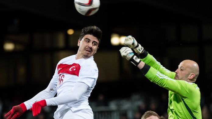 Na archívnej snímke brankár Luxemburska Jonathan Joubert, vľavo hlavičkuje hráč Turecka Ozan Tufan. 