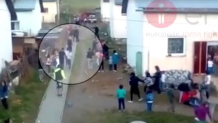 Policajti bijú Rómov.