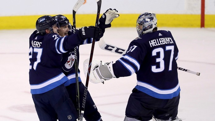 Hokejisti Winnipegu Jets Nikolaj Ehlers (vľavo), Mark Scheifele (uprostred) a brankár Connor Hellebuyck (vpravo)